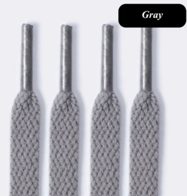 Gray flat shoelaces close-up with metal aglets on white background