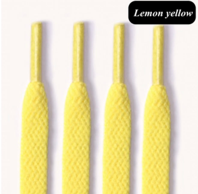 Four lemon yellow shoelaces with plastic aglets on a white background